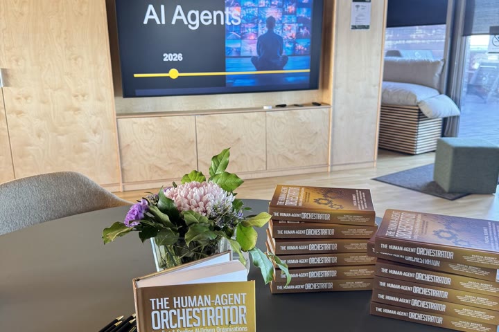 Copies of the book on a table in front of an AI agents presentation.