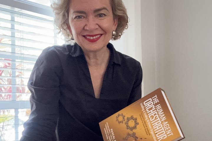 Tarja at a table with a stack of books.