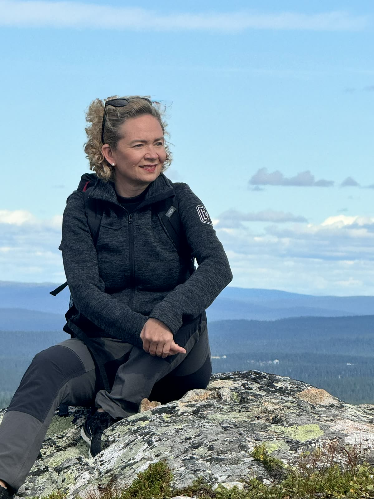 Tarja Stephens sitting on a rock above the Lapland fells